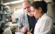 Doug Green, PhD, and a staff scientist work in the lab recording results.
