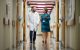 Brennan Bergeron and J. Raquel Collins, PhD, walk down hallway while engaging in discussion