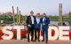 Attendees pose in front of an illuminated St. Jude sign, with cacti and desert landscape in the background. 