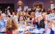 Celebrity Chef and Wine attendees raise auction ballots in a grand ballroom. 