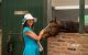 A St. Jude Day at the Derby attendee pets a horse's nose. 