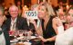 A St. Jude Detroit Gala attendee holds up an auction number and smiles. 
