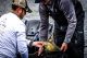 Two Dick Hiley Bass Classic participants hold up their catches and smile at weigh-in. 