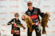 Two Dick Hiley Bass Classic participants hold up their catches and smile at weigh-in. 