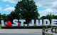 Golfers stand by large inflatable letters spelling 