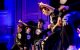 Kids dance on stage at Fitness for A Cure, with their arms raised overhead. 