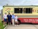 People standing in front of a food truck that says Tex-Mex.com