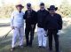 Four men on the standing on the golf course holding golf clubs