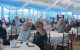 St. Jude Peninsula Golf Tournament attendees raise auction numbers in a dining room. 