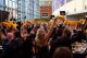 Attendees, seated at dining tables, wave orange napkins overhead at the Pittsburgh Gala. 