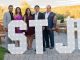 Attendees pose outdoors behind an illuminated St. Jude sign. 
