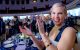 A St. Jude Fitness for a Cure attendee smiles and applauds at the Lowell Memorial Auditorium. 