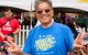 A man wearing sunglasses and a St. Jude Walk/Run T-shirt smiles and makes peace signs with his hands. 