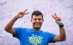 A man makes peace symbols with his hands and smiles in a St. Jude Walk/Run T-shirt. 