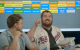 Content creators sit in front of a screen displaying the fantasy football draft. 