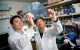 Young-Goo Han, PhD looks at a transparency in the lab with another staff member.