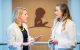 Heather Conklin, Ph.D., and Traci Olivier, Psy.D., talk in a hallway