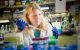 Researcher wearing lab coat and gloves working in the lab.