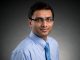 Headshot of scientist in blue shirt and tie.