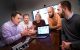 Five researchers discuss research around a computer.
