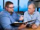 Two researchers discussing research while sitting at table.