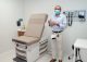 Researcher in mask standing in examination room.