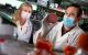 Research wearing masks look at samples in a lab