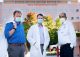 Three researchers in masks stand in front of St. Jude building.