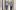 Two researcher wearing masks walk down a hallway while talking to each other.