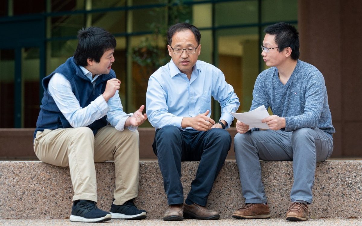 Three St. Jude scientists sitting on a step outside the Inspiration4 Advanced Research Center having a conversation