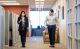 Two researchers in masks walking together down a hallway.
