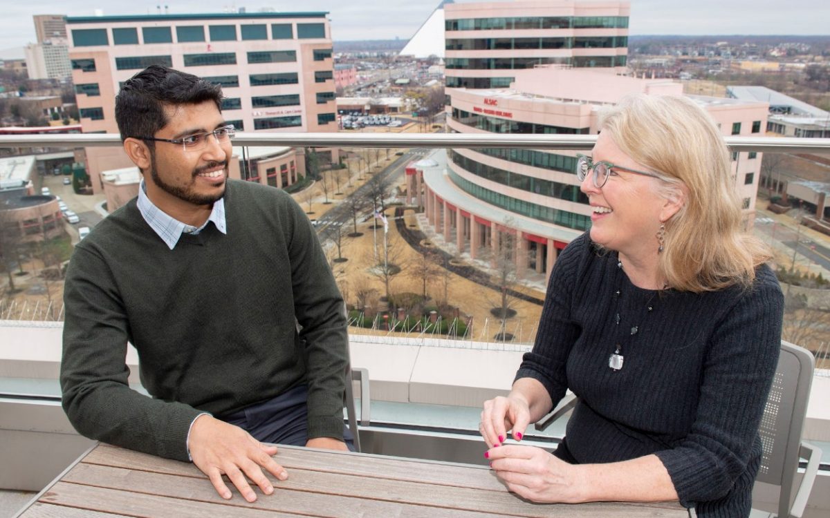 Two researchers sitting at a table on the roof of the Inspiration4 Advanced Research Center overlooking the St Jude campus.