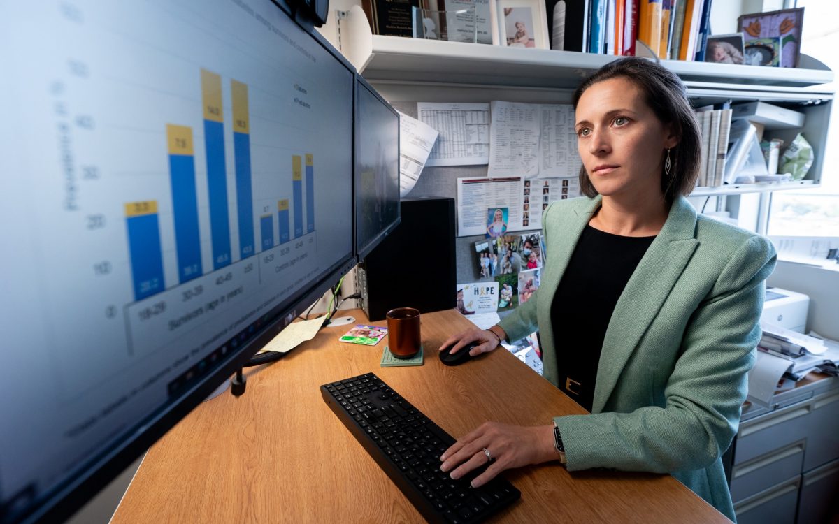 Stephanie Dixon, M.D., MPH, standing at desk looking at computer monitor