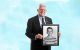 dwight tosh holds a photo of himself during treatment at st. jude