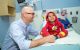 St. Jude physician talking to young male patient who is sitting on hospital bed