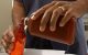 hands pouring medicine into vial