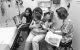 Patient is sitting chest to chest toward the parent with legs off to each side.