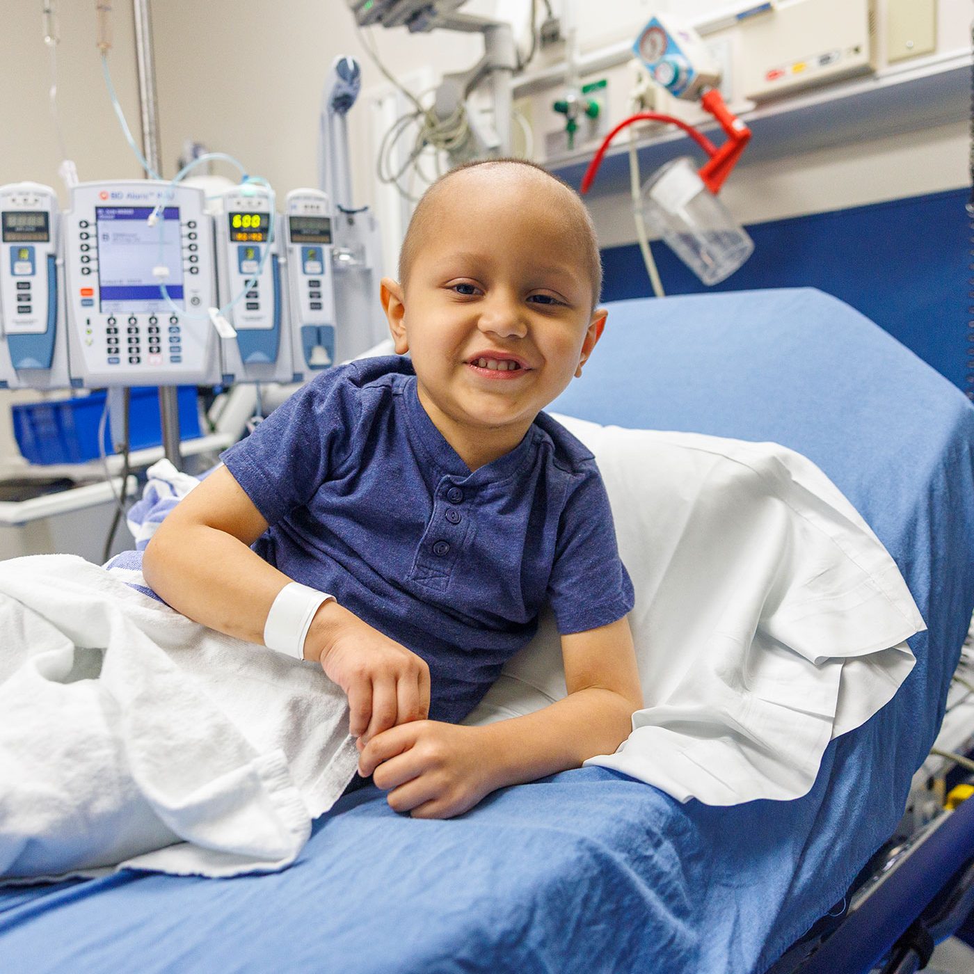 Leonel, paciente hispano de St. Jude sonriendo mientras se encuentra en una camilla del hospital.
