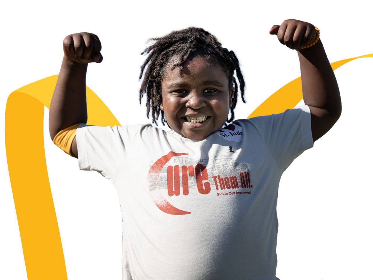 Bailey, paciente de St. Jude, frente a un lazo dorado.