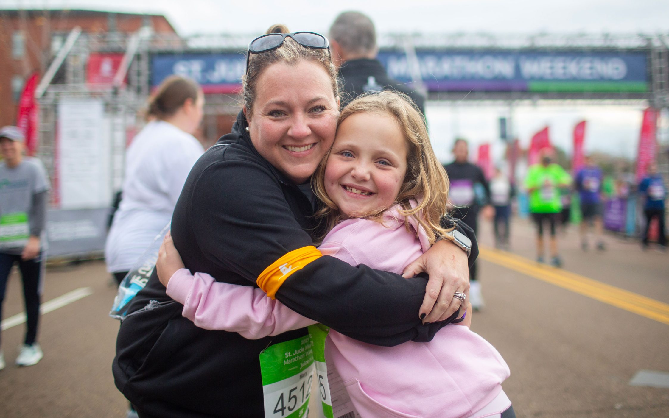 St. Jude patient Madison and her mom hug at the finish line.