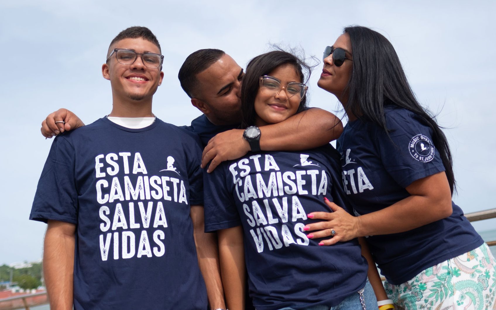 Patient Yazleemar receives hugs and kisses from her family, while standing on a boardwalk in Puerto Rico.