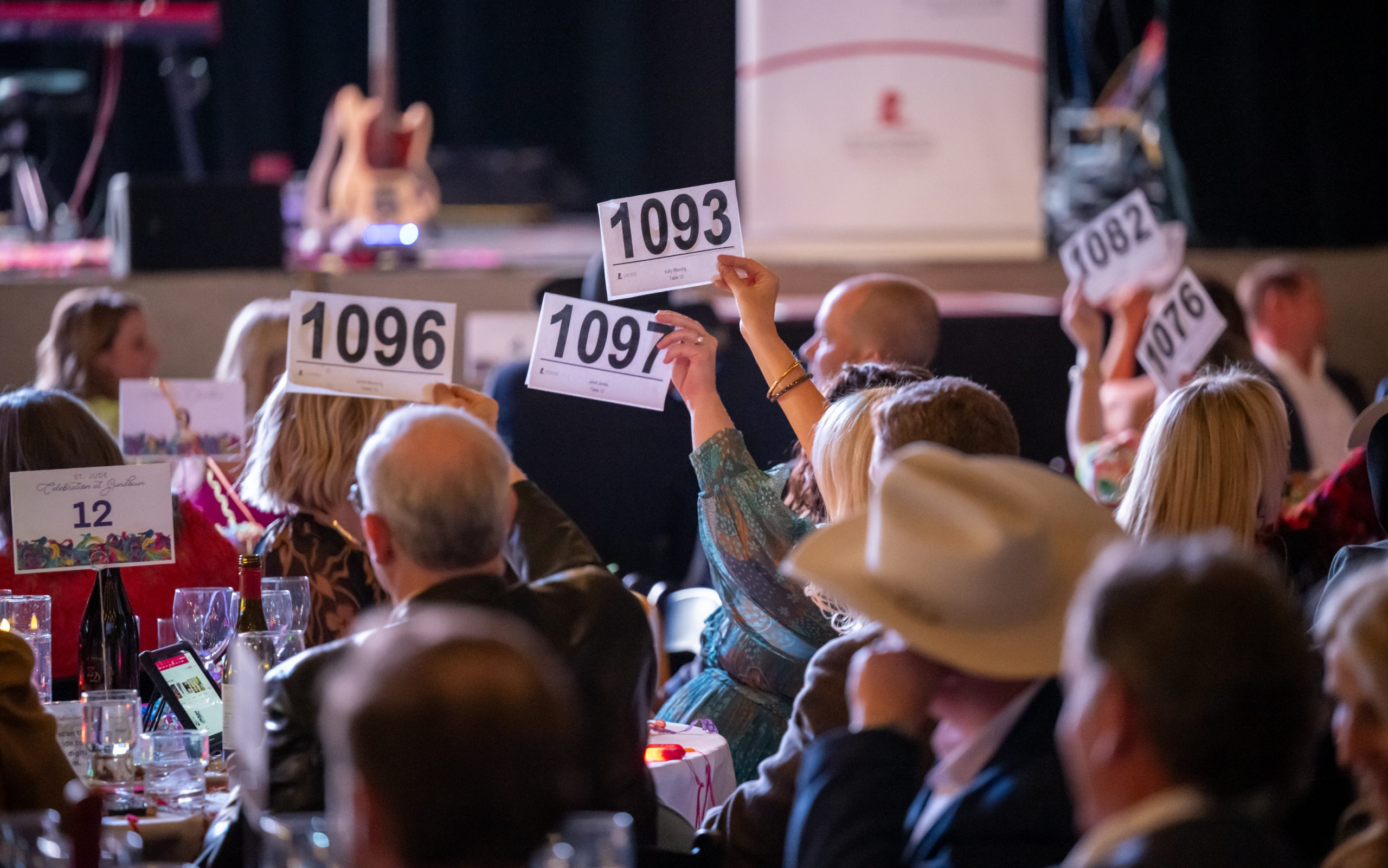 St. Jude Celebration at Sundown attendees raise auction numbers. 