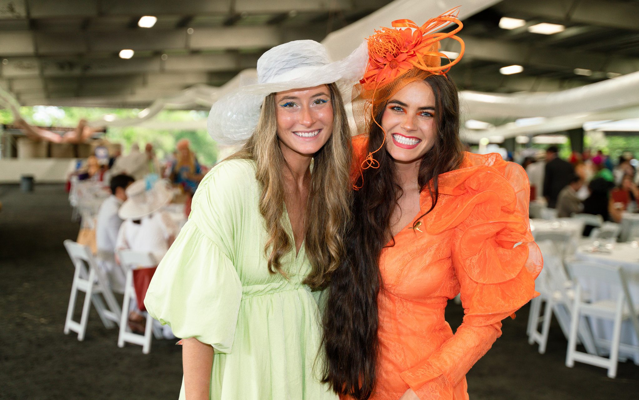 St. Jude Day at the Derby attendees smile in colorful hats and dresses. 