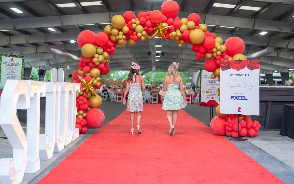A Day at the Derby attendees walk down the red carpet. 