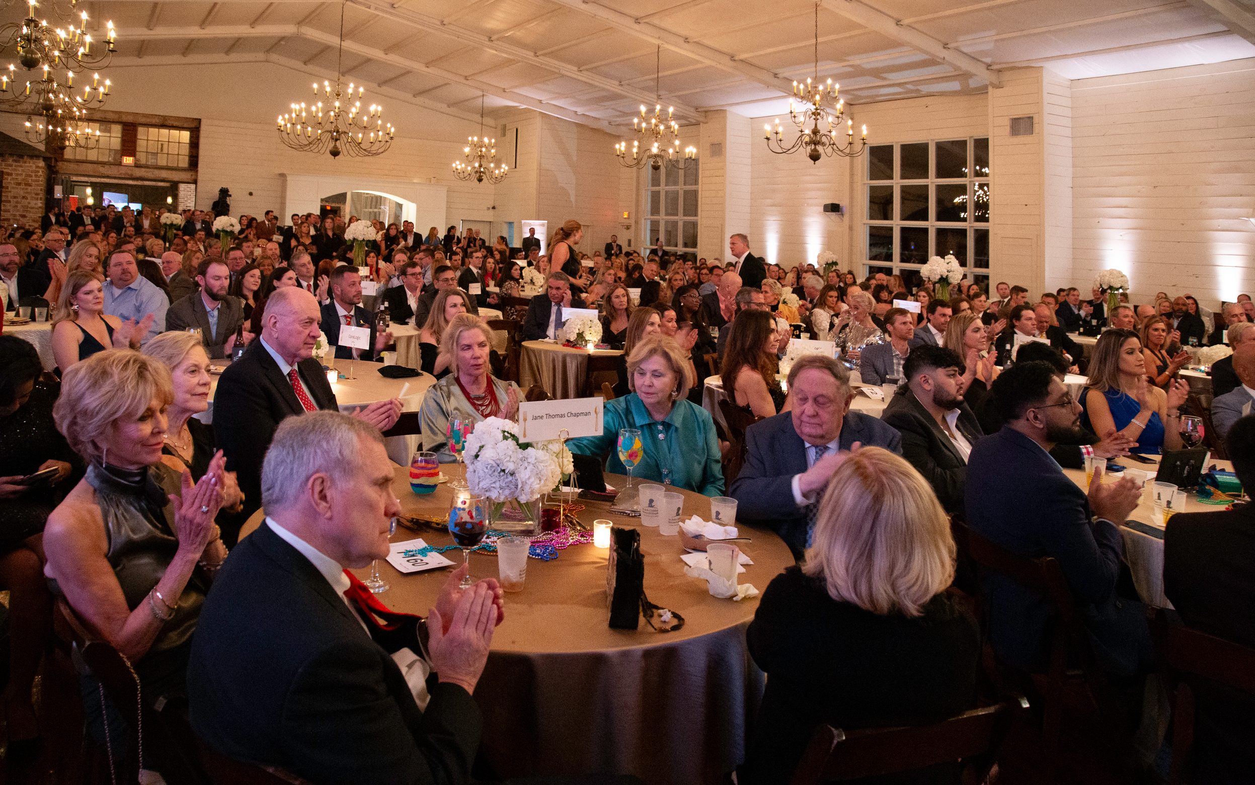 Taste of Oxford attendees sit at round tables and applaud at the 2024 event in Oxford, Mississippi. 
