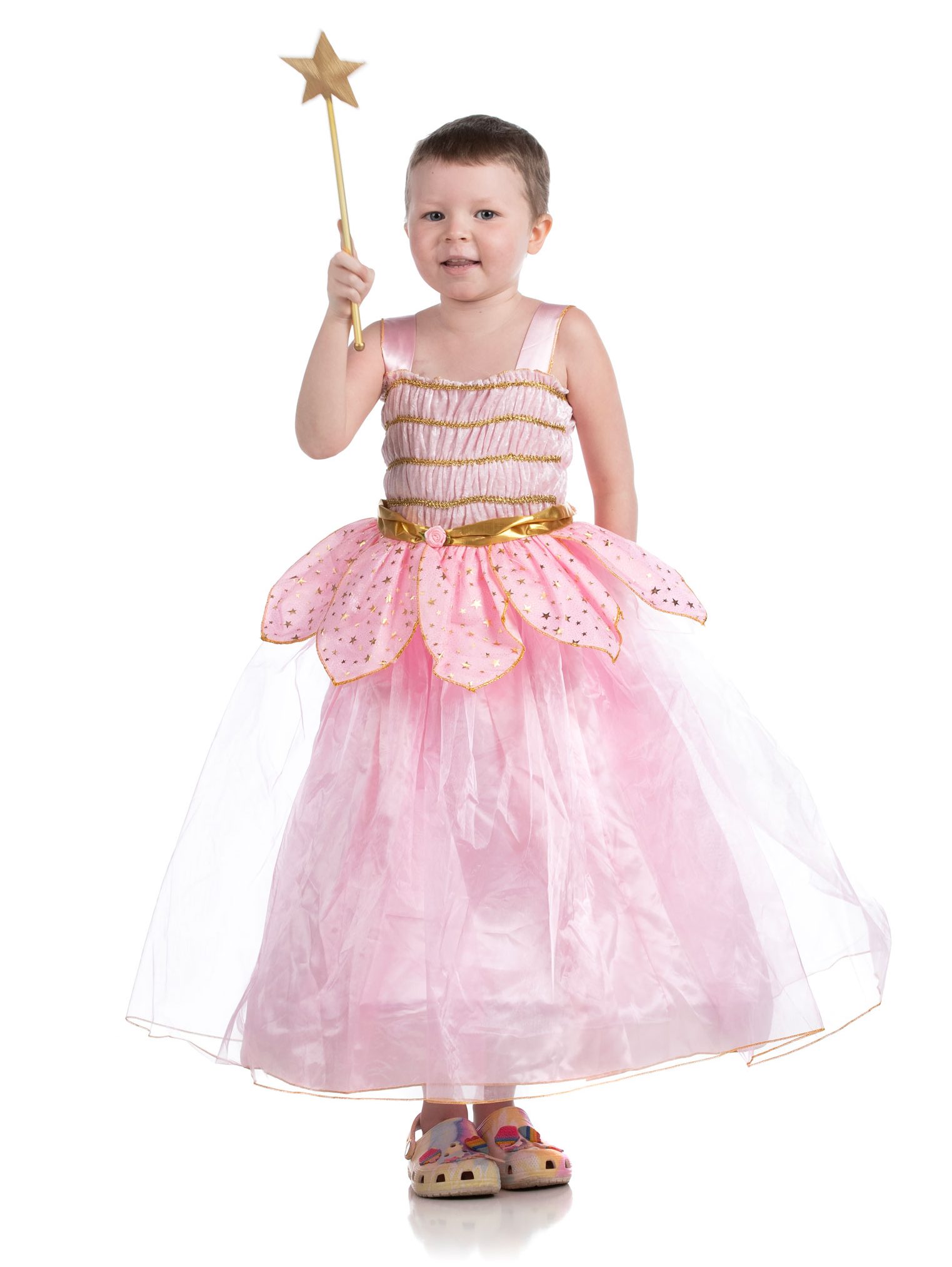 Patient Swayzie stands in a poofy pink dress holding a star-topped wand in one hand. 